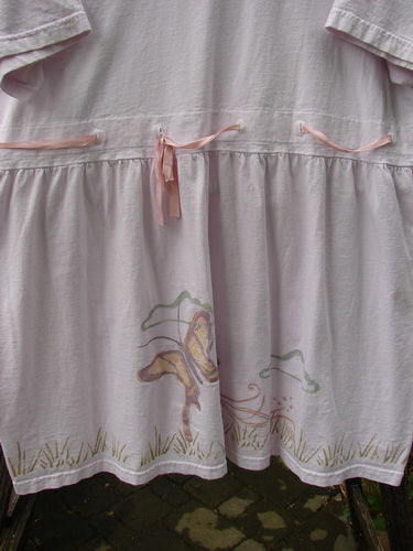 1999 Ribbon Dress Butterfly Orchid Size 2: Close-up of dress featuring a double-paneled rounded neckline, waistline with buttonholes, adjustable waist, gathered empire waist, bell shape, and butterfly-themed paint.