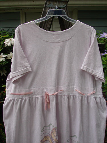 1999 Ribbon Dress Butterfly Orchid Size 2 on a hanger, featuring pink bows, double-paneled rounded neckline, adjustable empire waist, and butterfly theme paint. Made from organic cotton, perfect condition.