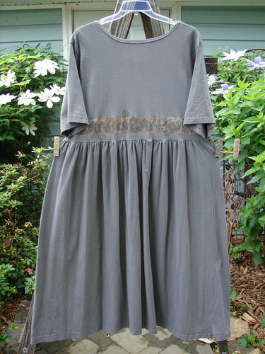 1992 Short Sleeved Simple Dress Vase Black Sand Size 1 hanging on a clothesline, showcasing its semi-dropped waistline, full draping lower, and uniquely placed Blue Fish patch.