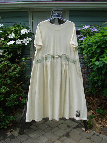 2000 Lulu's Dress Moon Window Milk Size 2 displayed on a swing hanger, showcasing its organic cotton fabric, drop yoke waist, pleated front darts, and wide, swingy lower section.