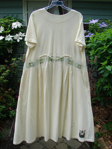 2000 Lulu's Dress Moon Window Milk Size 2: A white dress with green buttons, featuring a wide swingy lower, drop waist, pleated front darts, and four unique loops.