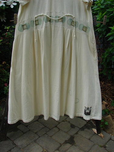 2000 LuLu's Dress Moon Window Milk Size 2 from Bluefishfinder.com, displayed on a clothesline, showcasing its drop waistline panel, button closure, wide lower, pleated darts, and unique moon window design.