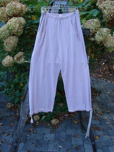 1999 Ribbon Pant Unpainted Orchid Size 1 features light lavender casual pants with an elastic waistband, side pockets, and drawstrings. Vintage Blue Fish Clothing from Bluefishfinder.com, perfect for a playful or flared look.