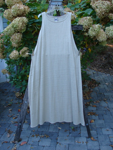 1998 Linen Knit Wrap Dress Unpainted Natural Size 2 displayed on a wooden ladder. Features wide armholes, round neckline, and side ties, showcasing its elegant drape and slender silhouette amid hydrangea backdrop.
