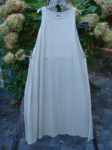 1998 Linen Knit Wrap Dress Unpainted Natural Size 2 hanging on a rustic ladder, showcasing a flowing linen knit with high-cut armholes, drawstring ties, and rounded neckline, embodying vintage elegance from Bluefishfinder.com.