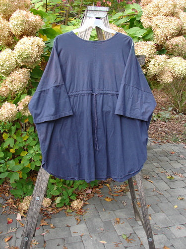 The Barclay Short Sleeved Pop Top Mosaic Fish Ridge OSFA features elbow-length sleeves, a drawstring waist, and a rounded hemline, draped over a wooden ladder, embodying Bluefishfinder.com's vintage, creative style.