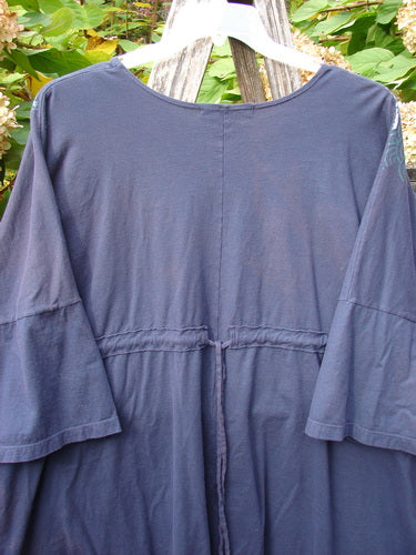 Barclay Short Sleeved Pop Top Mosaic Fish Ridge OSFA, displayed outdoors on a hanger, features a rounded hemline and drop shoulders, showcasing a layered mosaic fish theme on a loose-fitting silhouette.