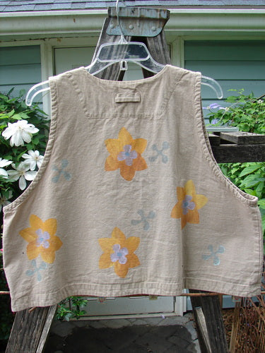2000 Parachute Cross Stitch Vest Sunset Floral Dove 0 featuring a tan base with yellow flower patterns, deep V neckline, four metal buttons, deep arm openings, and an A-line shape.