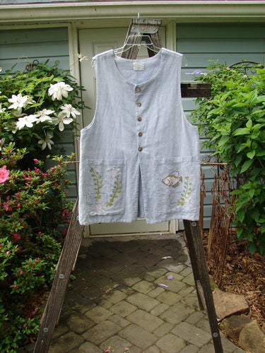 1999 Textured Linen 2 Pocket Vest Undersea Water Size 0 hanging on a wooden ladder, showcasing two oversized front painted pockets, five pearl buttons, and a blue fish patch.