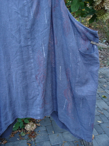 Barclay Linen Apron Jumper Celtic Rain Raven Size 2 features a loose-fitting, sleeveless design with a unique dot texture, patch pocket, and adjustable striped straps, hanging outdoors against a natural backdrop.