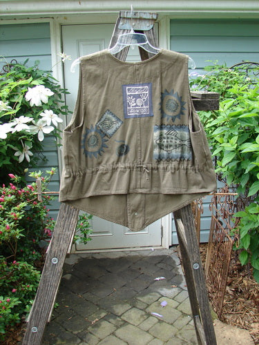 1995 Denim Invention Vest Fish Sun Bramble Altered OSFA displayed outdoors, hanging on a ladder, showcasing metal buttons, varying hemline, draw cord back, and signature Blue Fish patch.