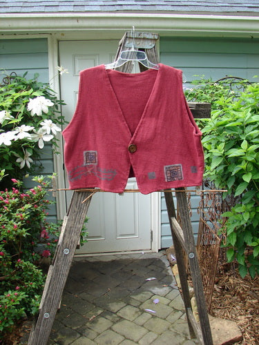 1995 Reprocessed Jazz Vest Vintage Car Hollyberry Altered Size 2 hanging on a wooden ladder, showcasing its patchwork design, single button closure, and shorter back hemline.