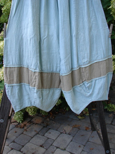 Barclay Linen Meadow Pant Twill Contrast Unpainted Sage Size 0 displayed on a wooden clothes rack, showcasing its full elastic waistline, gathered horizontal panels, and slightly cropped length.