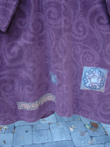 2000 Patched Upholstery Diwmach Coat Celtic Time Aubergine Size 2 features a textured fabric with swirling motifs, Celtic knot appliqués near the hem, showcasing Bluefishfinder.com's unique vintage elegance and individuality.