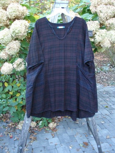 Barclay Flannel Keyhole Drawcord Pocket Dress Brum Plaid Size 2 displayed on a wooden ladder, showcasing its plaid pattern, keyhole neckline, and spacious pockets in a garden setting.