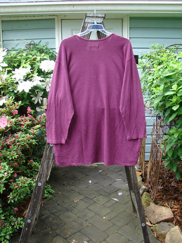 Barclay NWT Hemp Cotton Long Sleeved Studio Tee in Tyrian Berry on a wooden hanger, showcasing its rounded neckline, drop shoulders, wide sleeves, and generous shape.