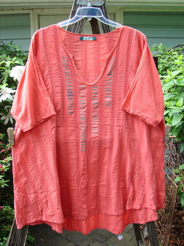 Barclay Linen Cotton Basket Weave Draw Back Tunic in Unpainted Sherbert, Size 2, displayed on a clothes hanger. Short-sleeved with a distinctive texture, showcasing vintage Blue Fish Clothing style.