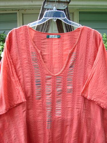 Barclay Linen Cotton Basket Weave Draw Back Tunic Unpainted Sherbert Size 2 displayed on a hanger, showcasing its short sleeves and elegant design.