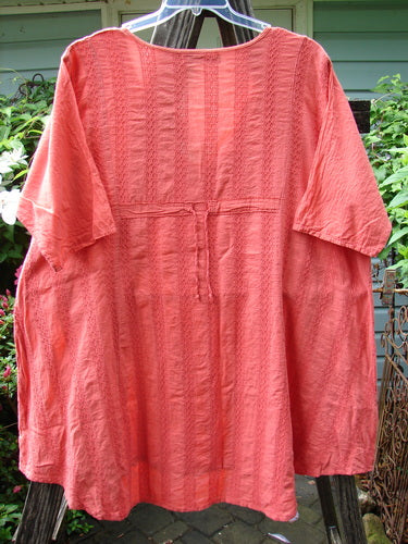 Barclay Linen Cotton Basket Weave Draw Back Tunic Unpainted Sherbert Size 2, short-sleeved, displayed on a hanger. Close-up detail highlights the intricate basket weave pattern and textile quality.