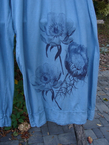 Light blue sweatshirt with dark-ink floral print draped on a hanger. Features Barclay Lightweight Crop Nepenthe Pant Poppy Garden Blue Teal Size 2, focusing on creative expression and individuality at Bluefishfinder.com.