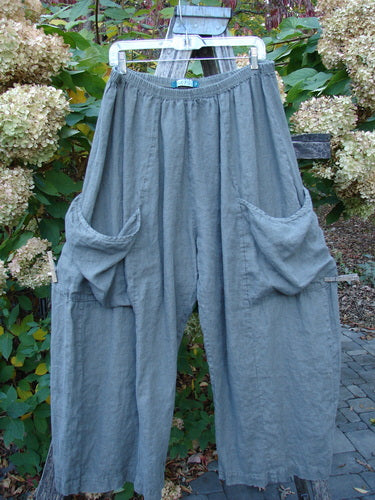 Barclay Lightweight Linen Side Pocket Pant Unpainted Army Stone Size 2 features loose-fitting, slate-gray cropped trousers with an elastic waistband and two large draped side pockets, styled for easy mix-and-match.