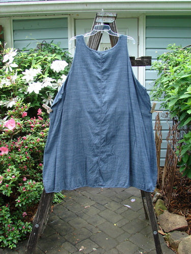 Barclay Lightweight Linen Pinafore Shift in Unpainted Blue Denim Stripe Size 2 displayed on a clothes rack outdoors, surrounded by greenery.