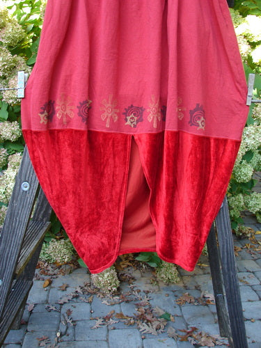 1996 Velvet Sophia Skirt: A red skirt with a bell-shaped upper and painted velvet lower panel. Features a rear kick vent and super pegged lower shape. Waist fully relaxed 30, fully extended 40, hips 60, length 39 inches.