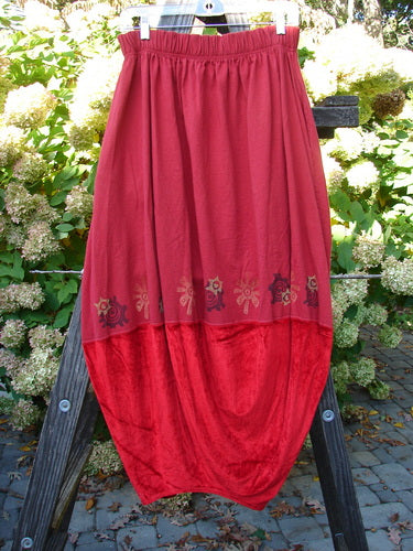 1996 Velvet Sophia Skirt: A red skirt on a stand, featuring a bell-shaped upper with a painted velvet lower panel. Rear kick vent, super pegged lower shape, and a 2-inch elastic waistline. Waist: 30-40, Hips: 60, Length: 39.