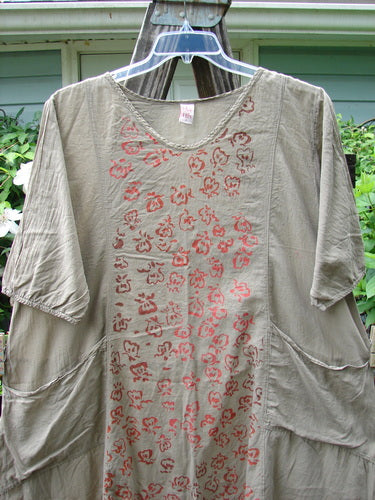 Barclay Batiste Bliss Dress Fallen Petal Stonetail Size 0 displayed on a hanger, showcasing a soft rounded neckline, short sleeves, two exterior pockets, and a drawcord back with a unique petal pattern.