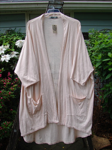 Barclay NWT Art Kimono Wind Dust Hush Pink Slub OSFA displayed on a hanger, showcasing its dolman sleeves and elegant drape.