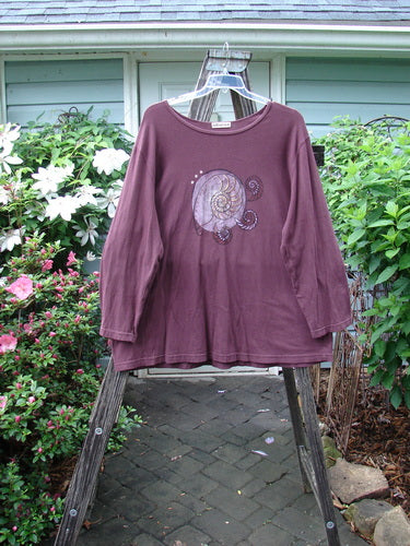 Barclay Long Sleeved Tee Spin Shell Deep Burgundy Size 3 displayed on a hanger, showcasing its A-line shape, wider boat neckline, long sleeves, and centered spin shell design.