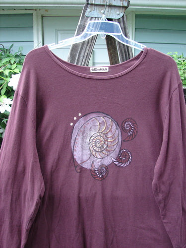 Barclay Long Sleeved Tee Spin Shell Deep Burgundy Size 3 featuring a centered snail design, wider boat neckline, and cozy long sleeves, showcasing a swinging A-line shape from mid-weight organic cotton.
