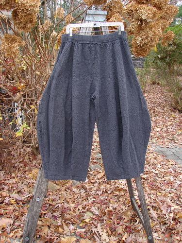 Barclay Pucker Crop Mojo Pant Unpainted Ironworks Size 1 hangs outdoors, showcasing its unique 3D diamond cut from knee down, generous front pockets, and full elastic waistband, set against fallen autumn leaves.