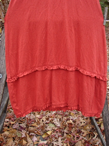 Red ruffled garment draped outdoors, the 2000 Wool Pointelle Lulu Slip Dress Sienna Smaller Size 0 showcases a widening flair with horizontal lower lettuce edging, inviting layering in vintage Blue Fish style.