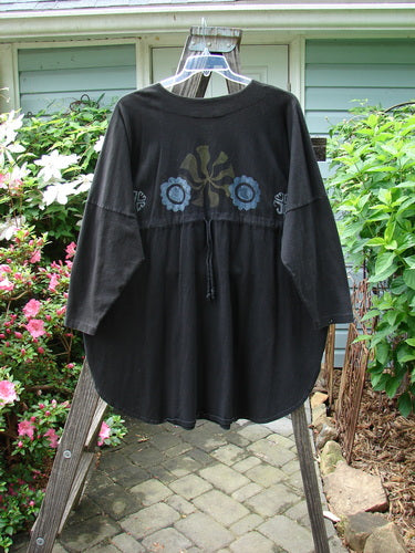 1997 Masquerade Top Celtic Continuum Obsidian OSFA displayed on a hanger, showcasing its teardrop neckline, rounded hemline, drop shoulder seams, and intricate Celtic Continuum theme paint, emphasizing its vintage charm.
