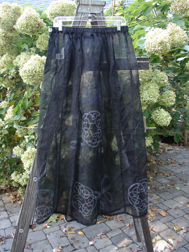 2000 NWT Silk Organza Skirt Wind Turn Celtic Turn Black Size 2 displayed on a wooden rack, highlighting its elegant A-line flare and full elastic waistline with a button closure.