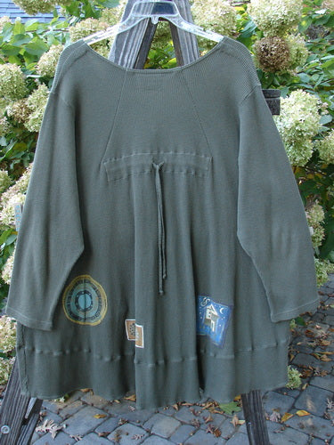 Barclay Patched Thermal Touring Cardigan Lucky Guy Pond Green OSFA displayed on a wooden rack, showcasing its flared hem, deep V-neck, mixed vintage buttons, and kangaroo-style pocket.