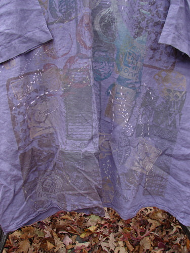 Barclay Linen Oversized Gallery Dress Home Fall Violet OSFA draped over autumn leaves, featuring a rounded neckline, drop shoulders, three-quarter dolman sleeves, with a faint, multi-colored graphic print.