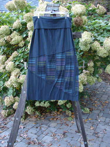 Barclay Cotton Lycra Fold Over Column Skirt Zig Zag Stripe Blue Mineral Size 1 displayed on a wooden rack; features fold-over waistline, zig-zag stitching, and lettuce edge hem.