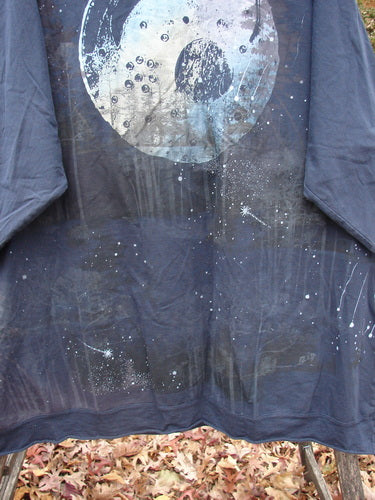 Barclay Cotton Lycra Flutter Hem Dolman Pullover Centered Ink OSFA features a moon and star design, displayed outdoors with autumn leaves, highlighting its loose fit and unique artistic print.