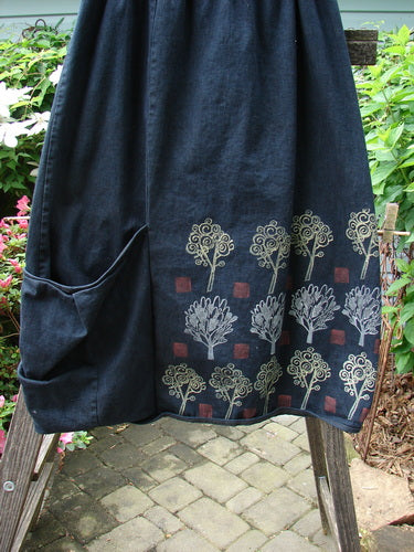 Barclay Heavy Weight Denim Belted Pocket Skirt Tree Black Indigo Size 2, featuring white floral patterns, a thick elastic waistline, oversized front pocket, and vertical panels with a forest theme design.