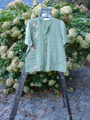 1998 Botanicals Robin's Top Mixed Garden Elm Size 1 displayed on a wooden hanger, featuring dual front elastic-topped pockets, seven buttons, and a garden theme print.
