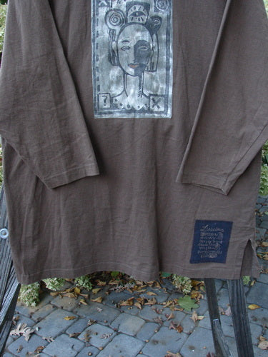 1996 Everyday Jacket Inner Woman Molasses Size 2: A brown shirt with a drawing of a woman. Scribe buttons, oversized painted drop pockets, and Blue Fish patch.