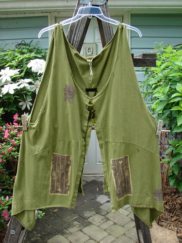 1993 Holy Vest Mythical Door Olive Size 2 hanging on a clothesline, showcasing its open front, side vents, velvet ribbon accents, varying hemline, and sectional panels against an outdoor backdrop.