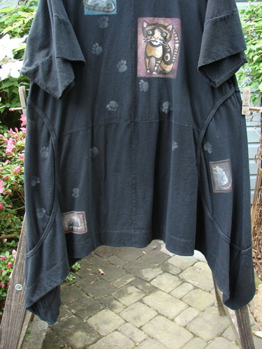 Barclay Double Pocket Bounce Tunic Dress Cat & Mouse Black Size 2, featuring cat and paw prints, oversized front pockets, and a dramatic scooped hemline, made from medium-weight organic cotton.