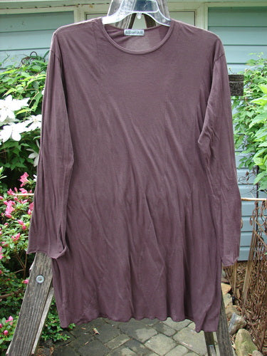 Barclay Batiste Tunic Curve Top Unpainted Red Earth Size 2: A long-sleeved tunic with curvy seams, narrowing forearms, and a rounded neckline, displayed on a clothes rack.