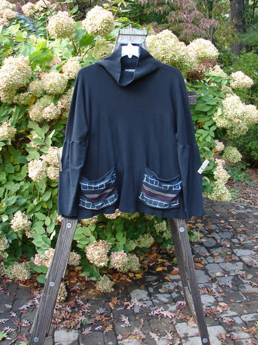 A black Pullover on a wooden stand, featuring a Barclay Patched Thermal Tie Back Cowl Top Lucky Wind Black Size 3.