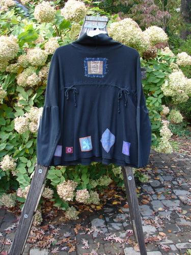 Image alt text: Barclay Patched Thermal Tie Back Cowl Top Lucky Wind Black Size 3 - A black jacket with patchwork designs and a double cowl turtleneck, featuring exterior stitchery, drop pockets, and dolmen sleeves.