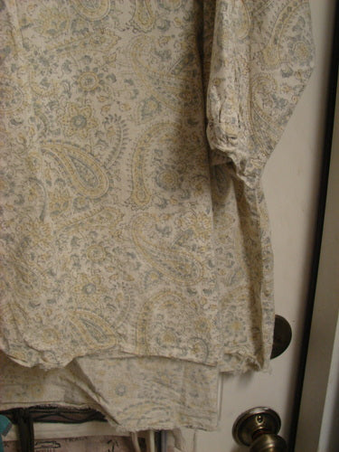 Magnolia Pearl NWT European Cotton Bondi Blouse Fleuri OSFA draped over a white door, showcasing its paisley print, raw-edged V neckline, and billowy sleeves, reflecting Bluefishfinder.com's vintage, expressive style.