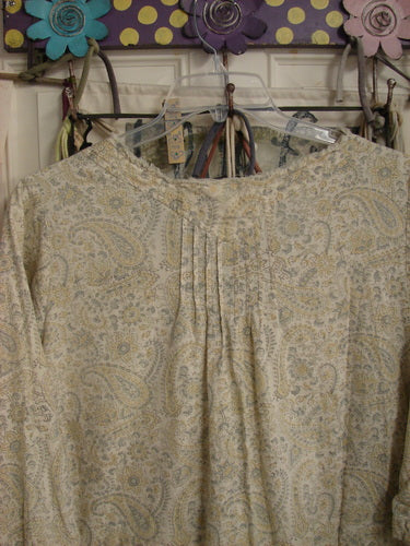 Magnolia Pearl NWT European Cotton Bondi Blouse Fleuri OSFA: Feather Weight, paisley print, featuring pintuck plackets, raw-edged neckline, lace-trimmed collar, and billowy sleeves, hanging decoratively on a floral wall hook.